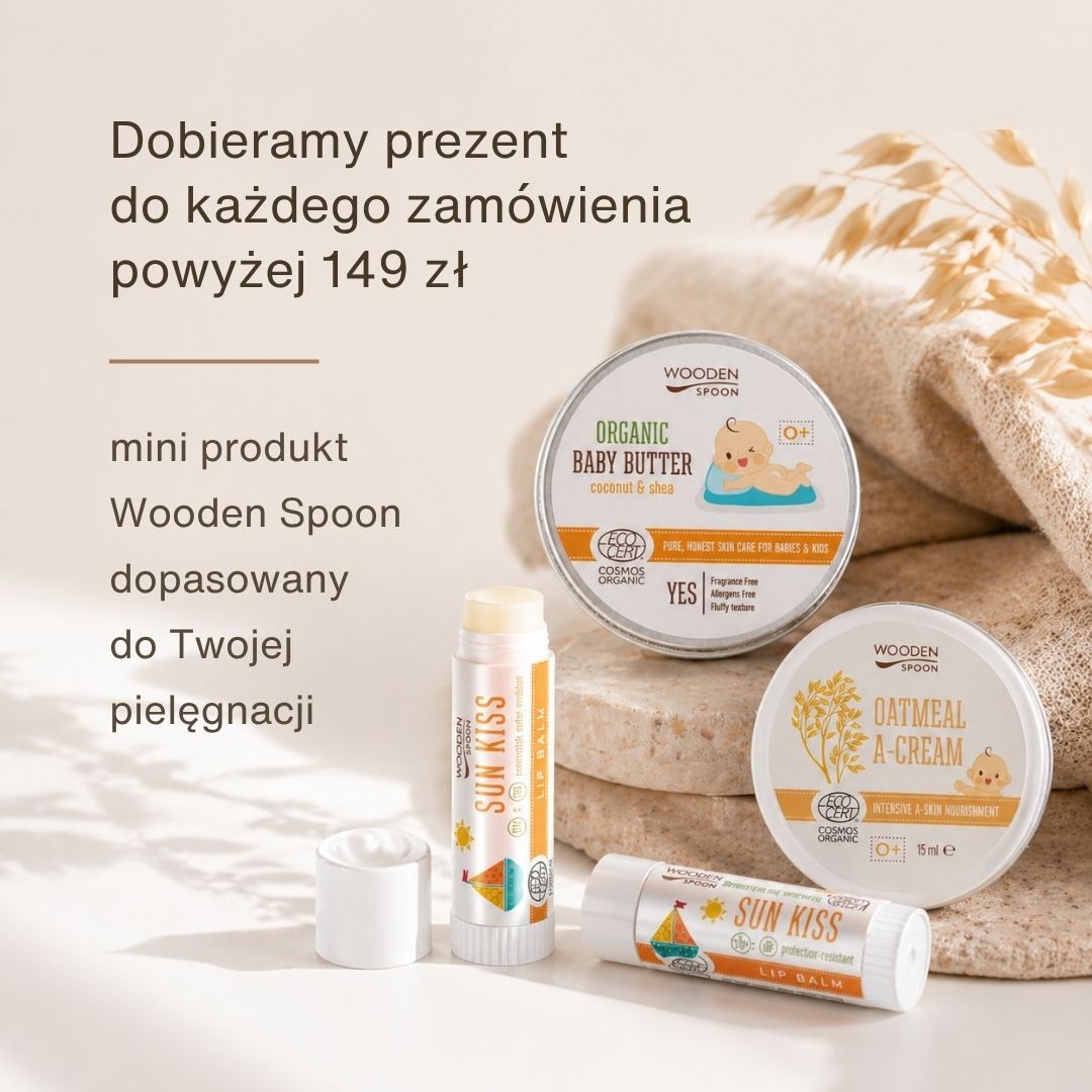 Na zdjęciu znajdują się trzy produkty kosmetyczne ułożone na płaskiej powierzchni.  Na dole widoczna jest podłużna pomadka ochronna do ust w formie sztyftu, ułożona poziomo. Nad nią znajdują się dwa okrągłe opakowania masła do ciała – mają ten sam rozmiar i są ustawione obok siebie.  Po lewej stronie znajduje się masło dla dzieci, po prawej krem owsiany.  Produkty są ustawione blisko siebie, tworząc prostą kompozycję. Górna i lewa część grafiki pozostaje pusta – przeznaczona na tekst.